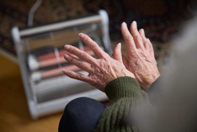 Heating hands in front of electric fire